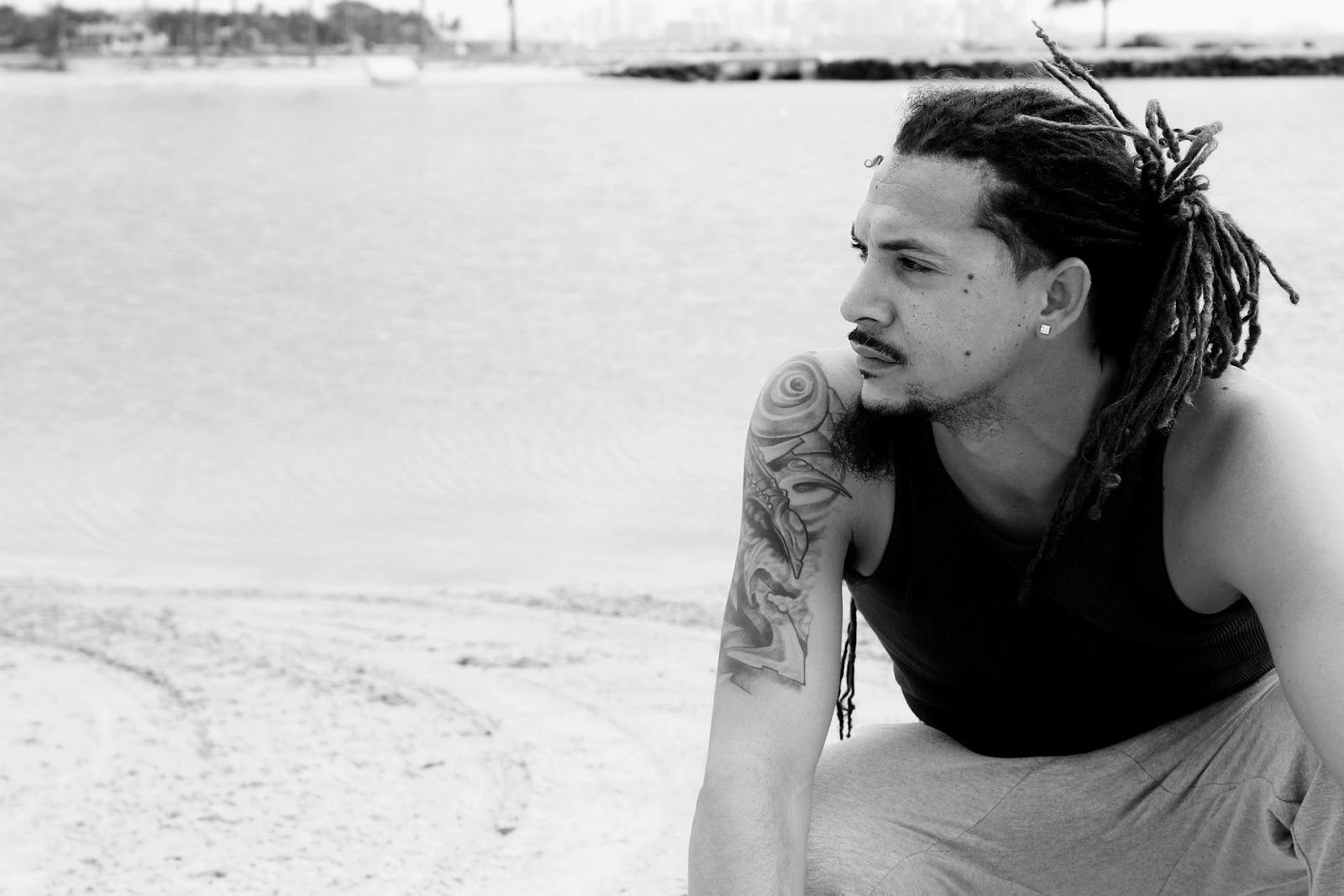 Black and white image of man with dreadlocks.
