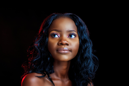 A beautiful black woman with chemically relaxed hair looking off-camera.