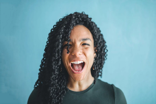 A woman with twisted hair yelling happily. 