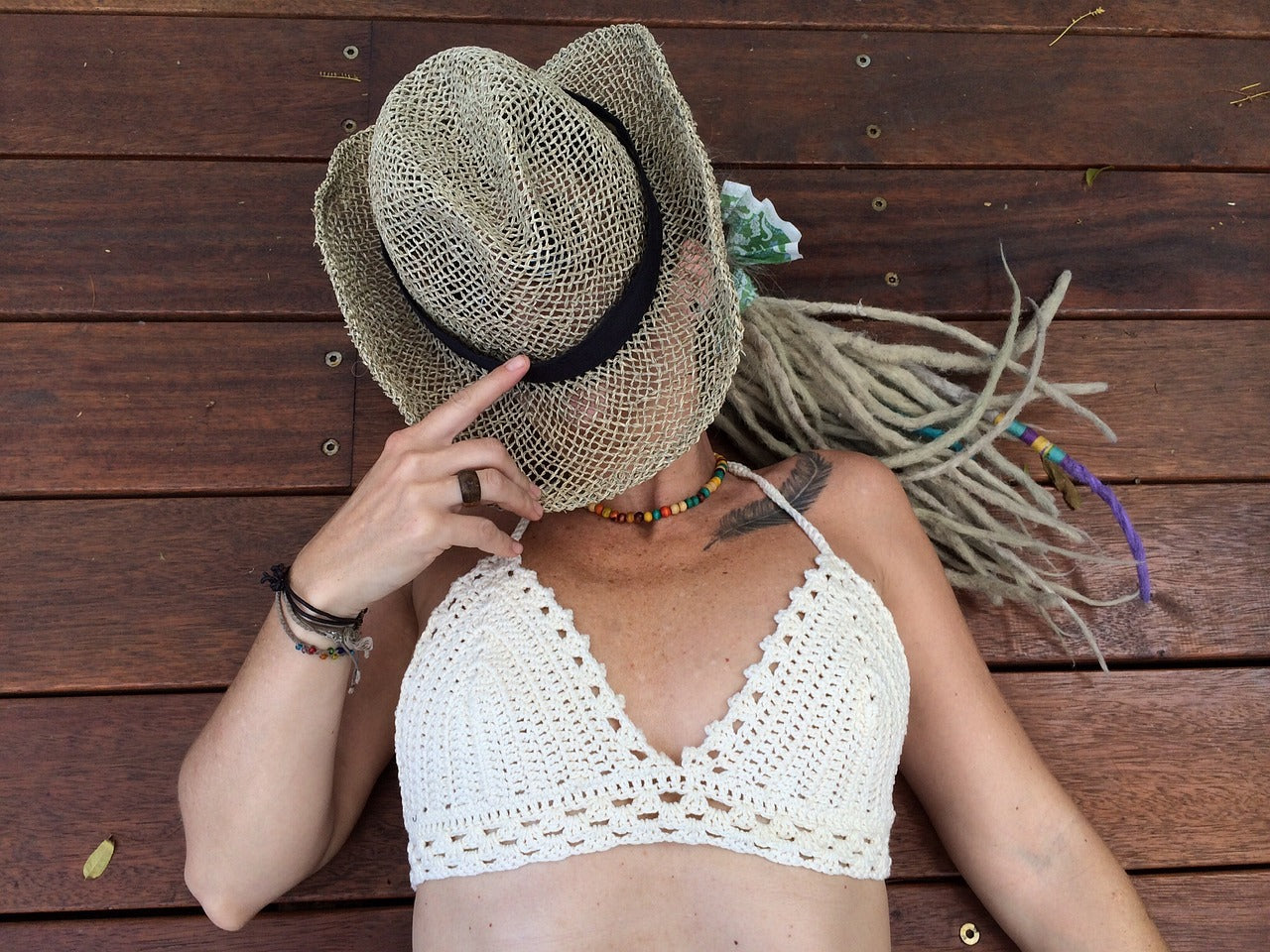 a woman with dreadlocks laying down with her face covered