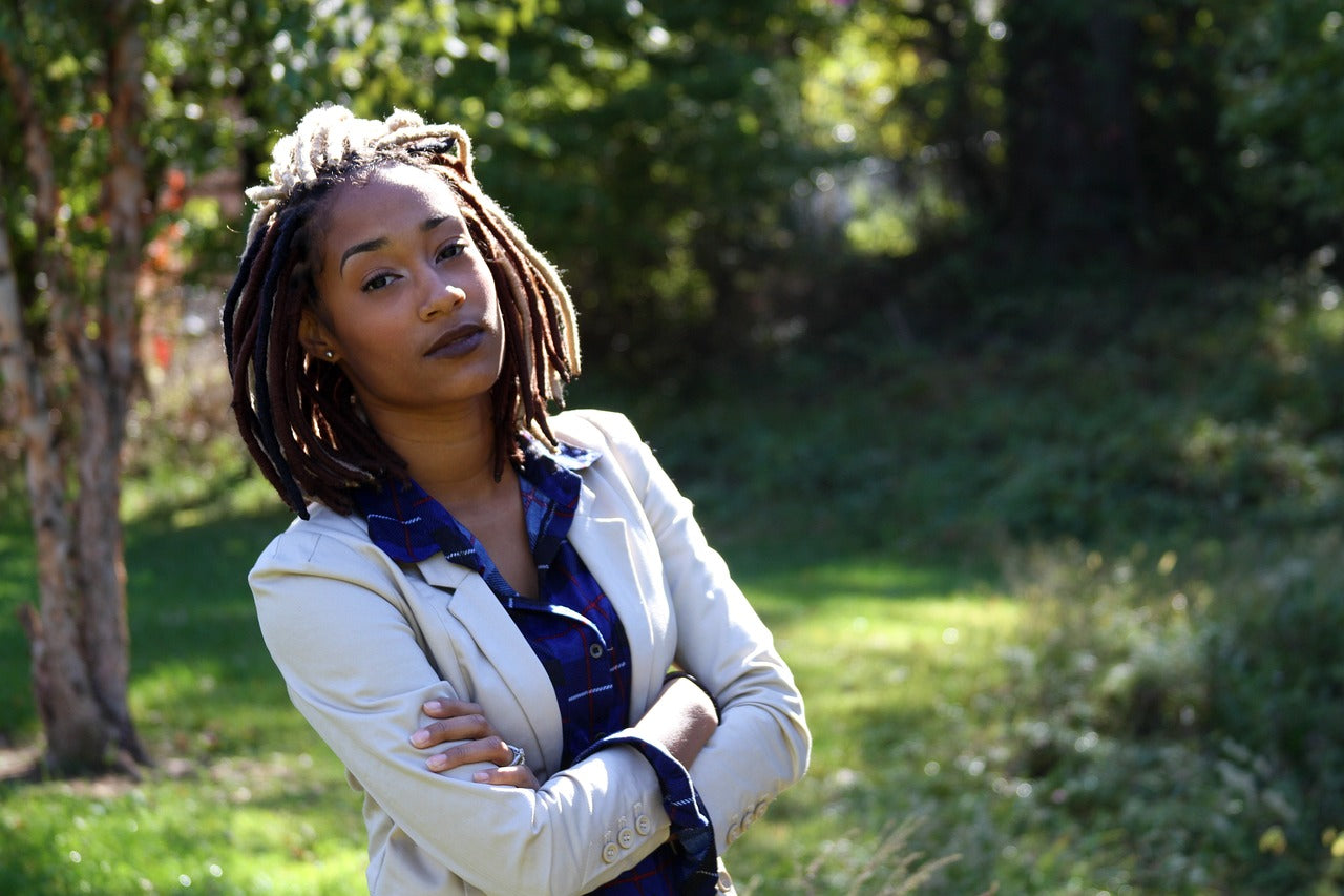 A female with dreadlocks and crossed arms