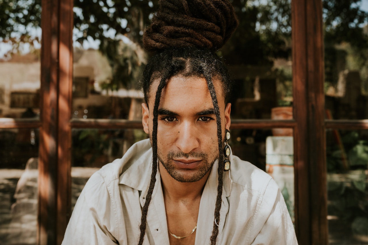 a man with dreadlocks looking at the camera