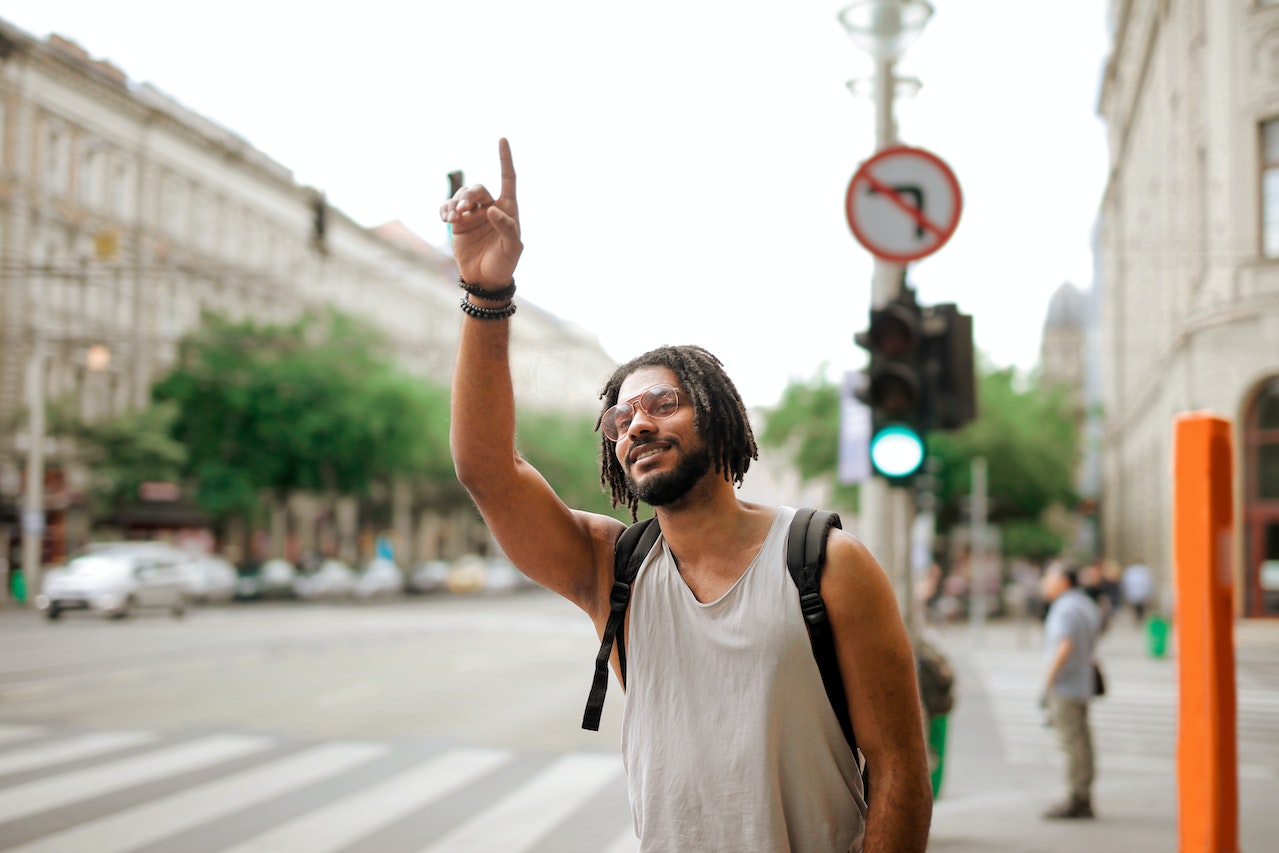 A man with dreadlocks hailing a cab in Paris