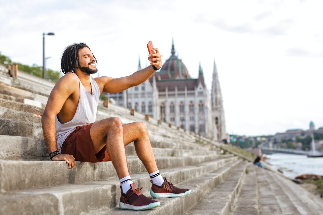 a man with dreadlocks taking a selfie 