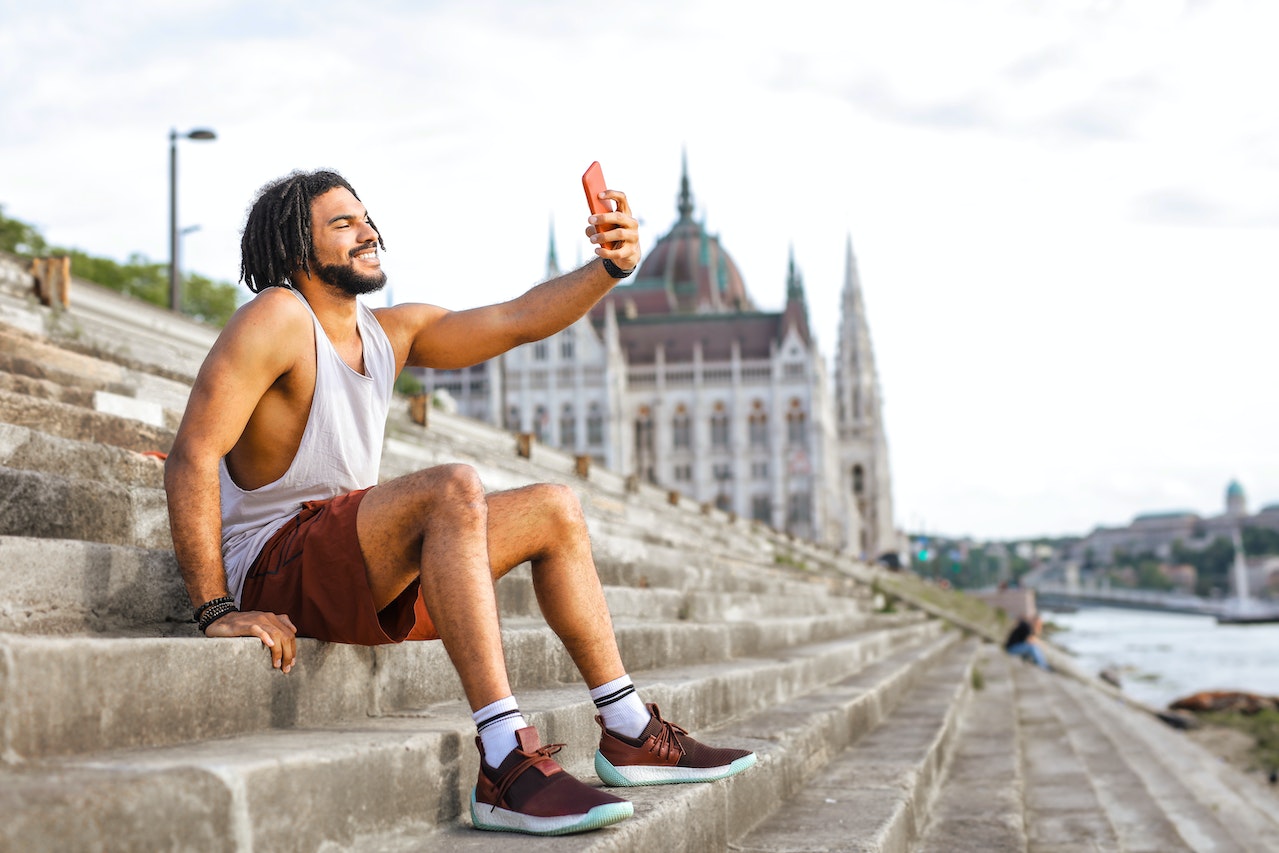a man with dreadlocks taking a selfie