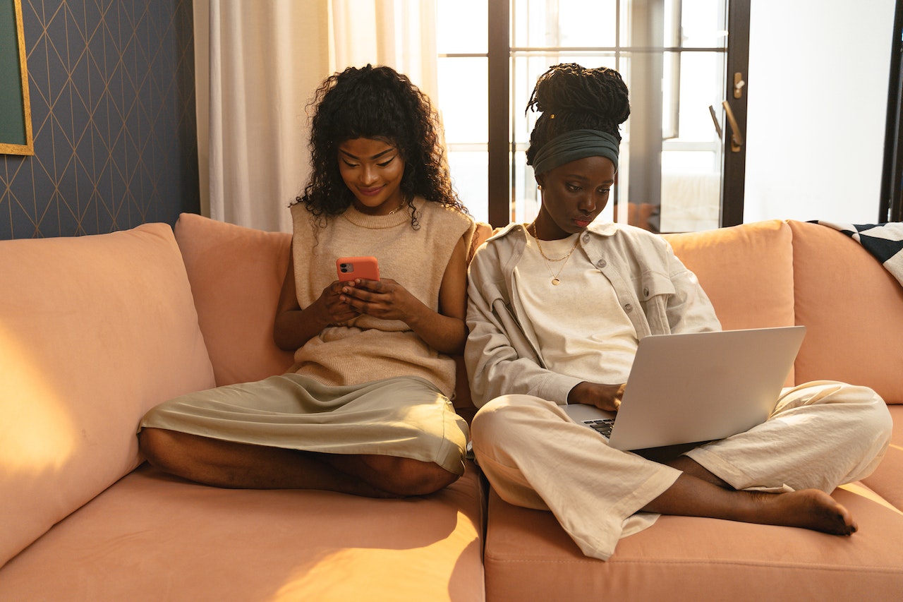 two women sitting on a couch