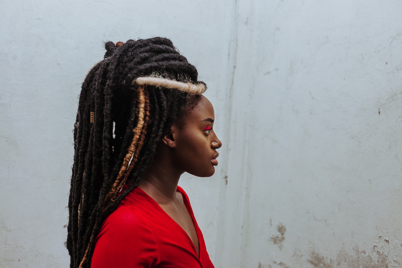a woman with a red shirt looking at a wall