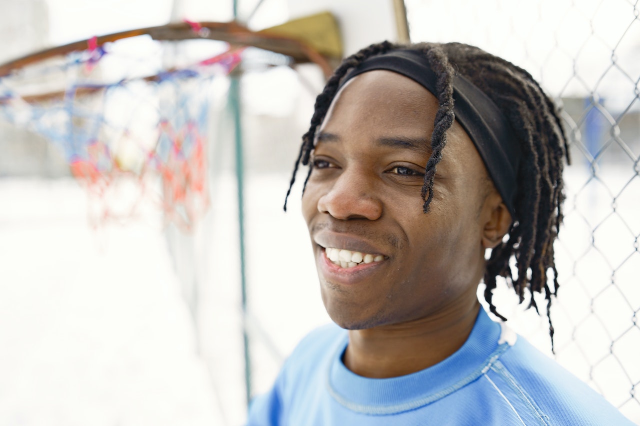 up close photo of a man with dreadlocks smiling