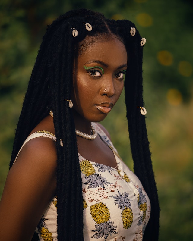 A woman with dreadlocks staring at a camera