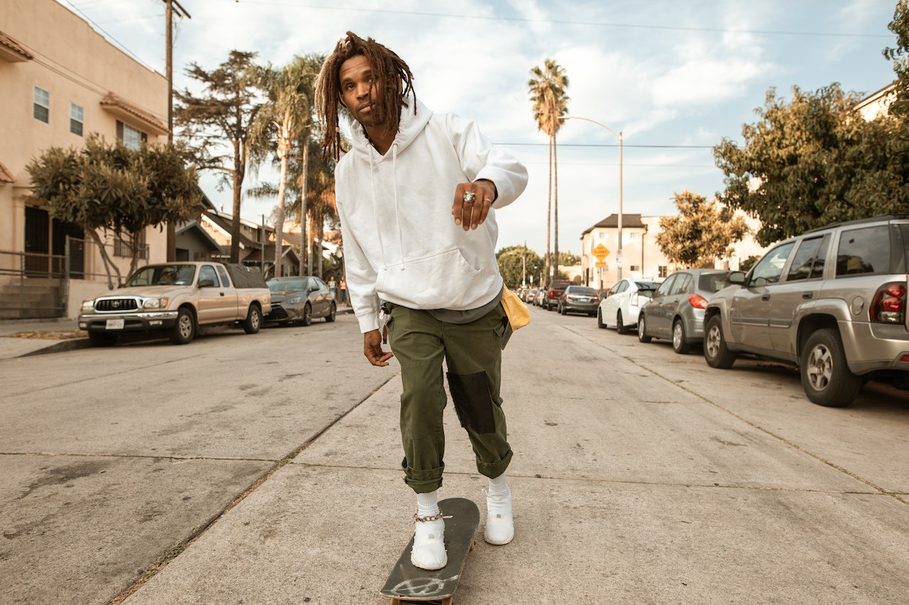 a man with dreads riding a skateboard