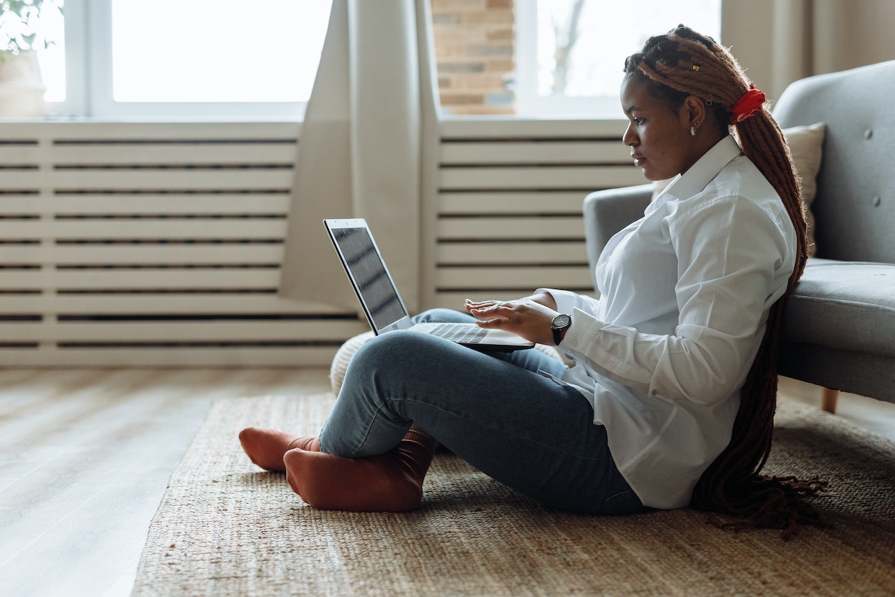 woman with dreadlocks typing on a computer