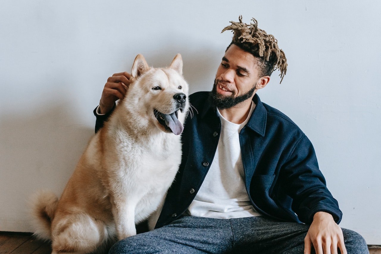 a man with dreadlocks and his dog