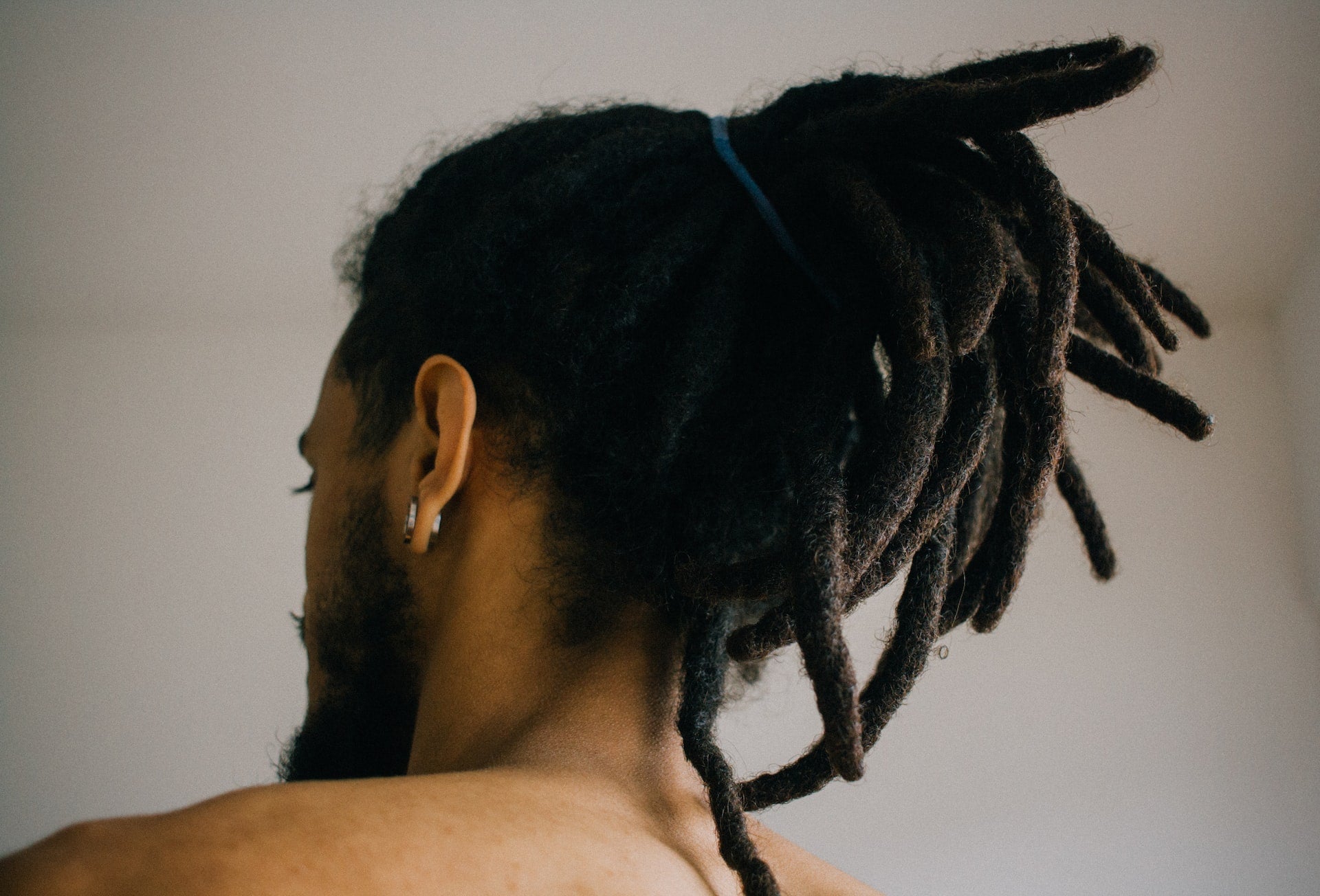 man with dreadlocks looking at a wall