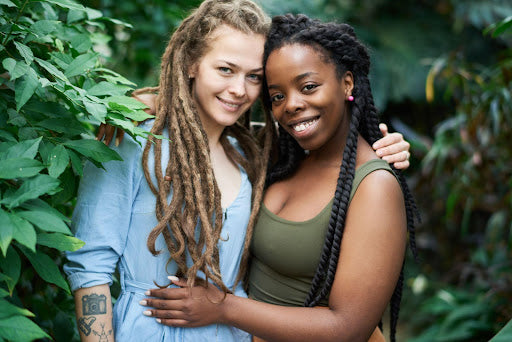 Two women with dreadlocks - one black and one white.  