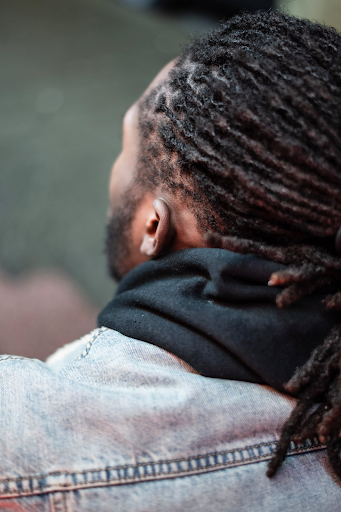 Close-up view of a black man with dreadlocks from the back.