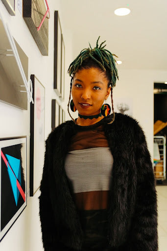 A person with short locs partially dyed green.