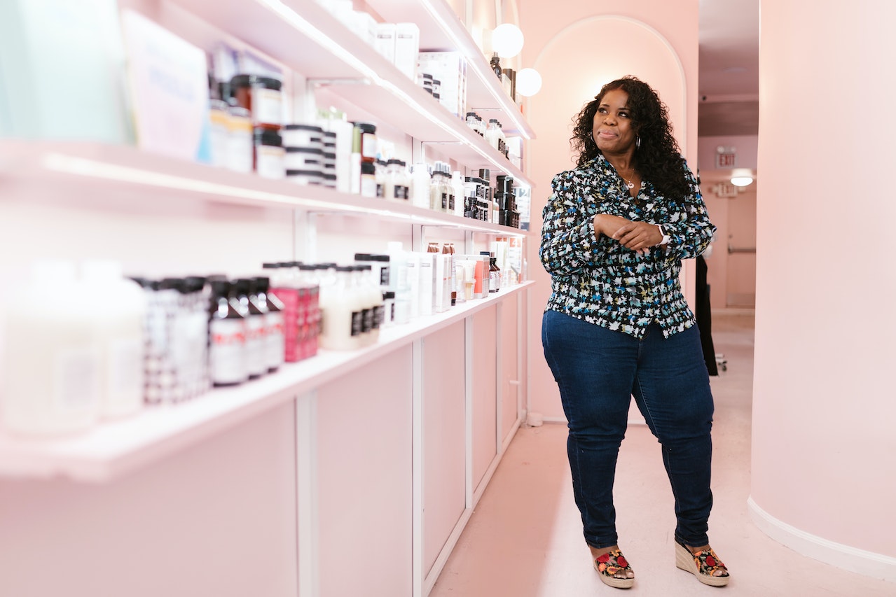 A woman looking at beauty products on a shelf 